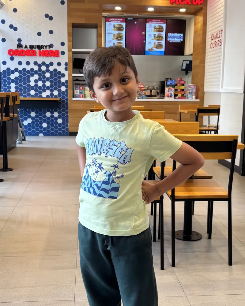Samar smiling with one hand on his hip